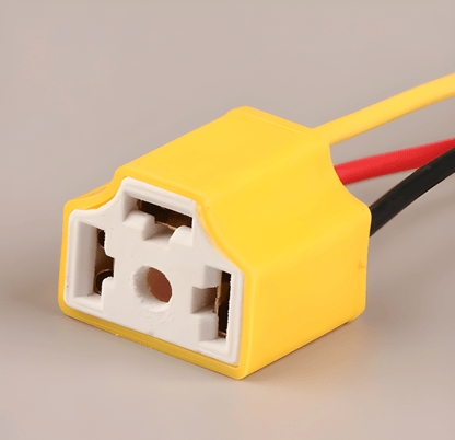 Close-up angled view of the H4 headlamp socket highlighting the heat-resistant white ceramic 3-pin core designed for high-temperature stability.