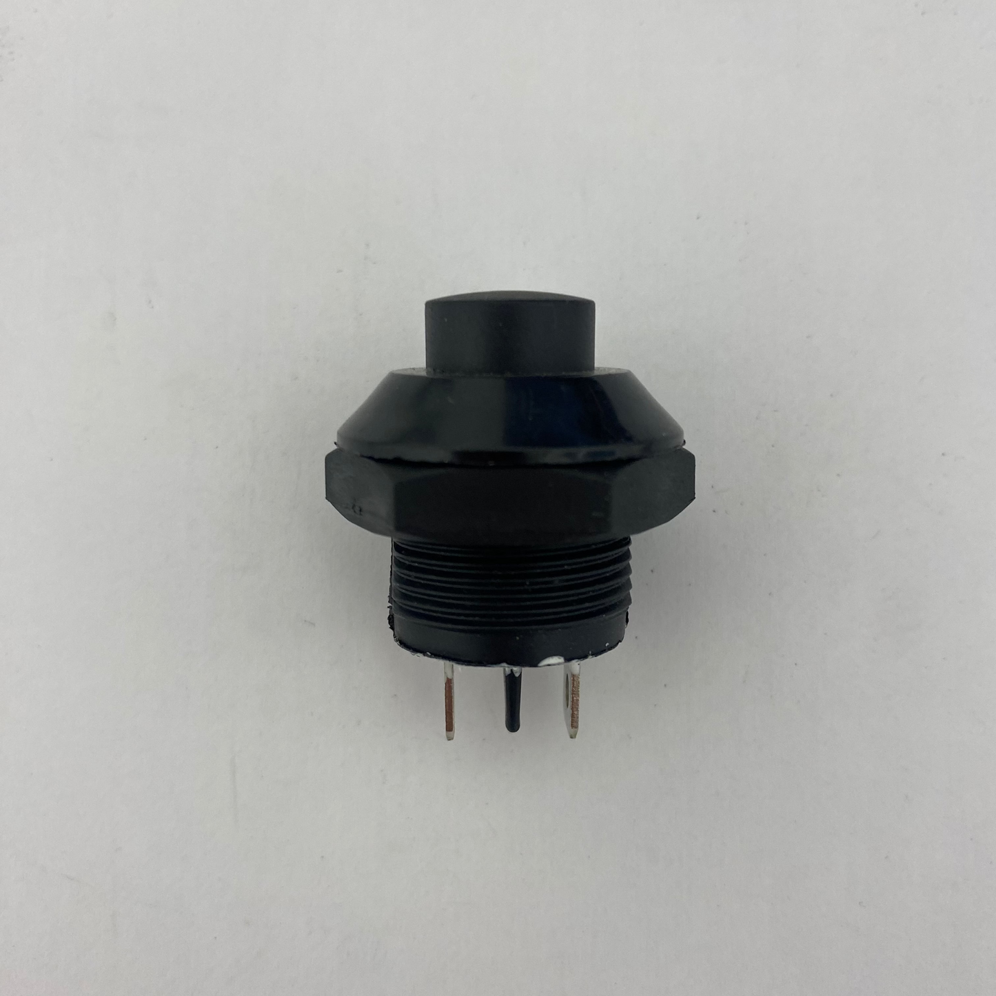 Black mechanical push button momentary switch on a white background
