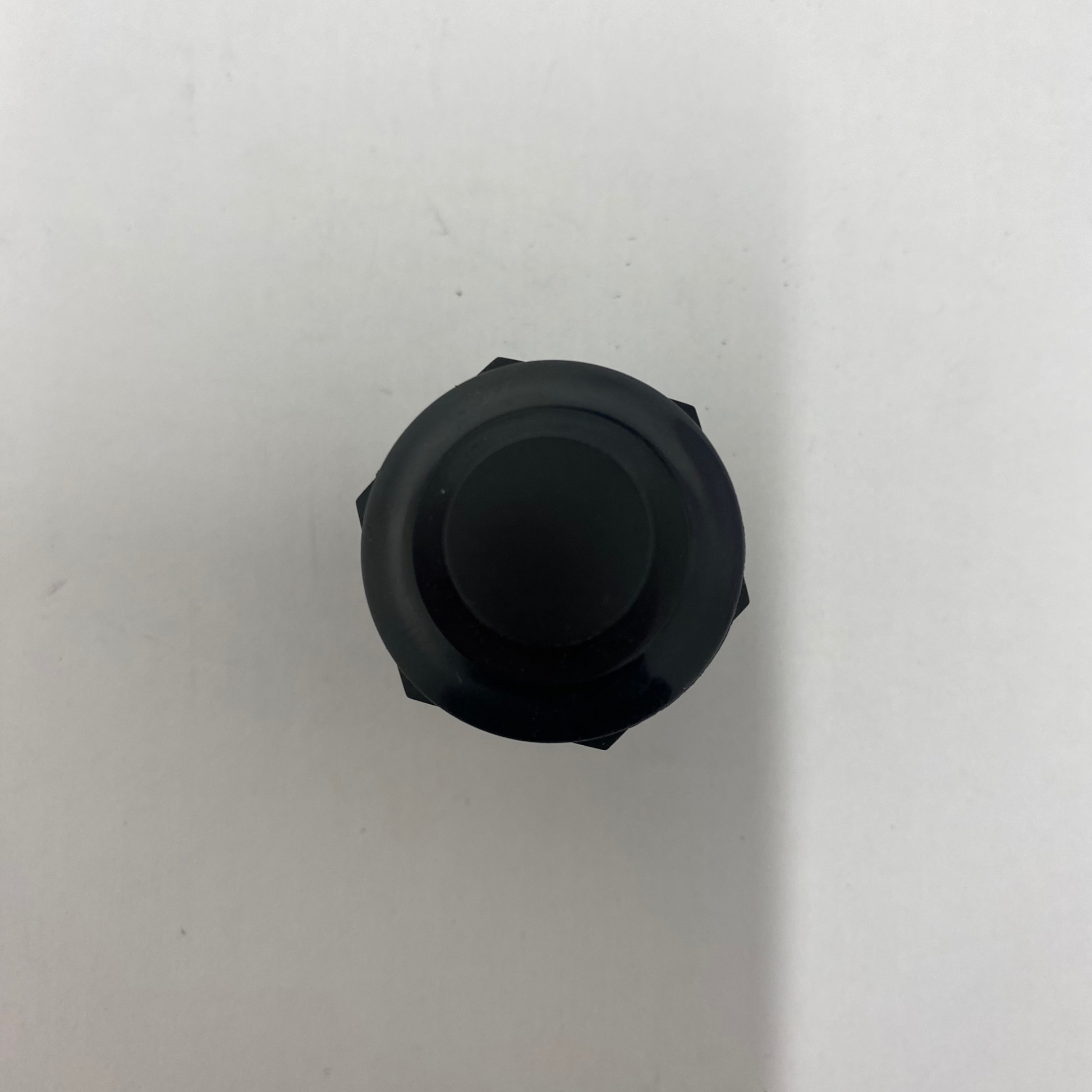 Black hexagonal push button momentary switch on a white background
