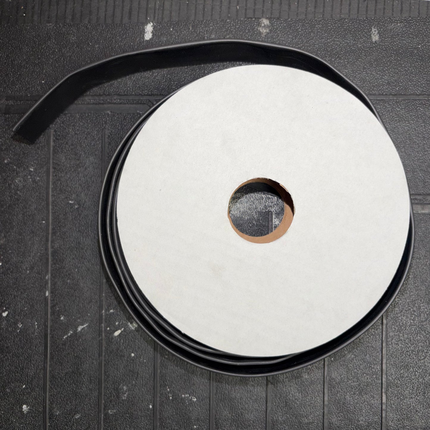 Top-down view of a mini reel spool wrapped with black heatshrink tubing.