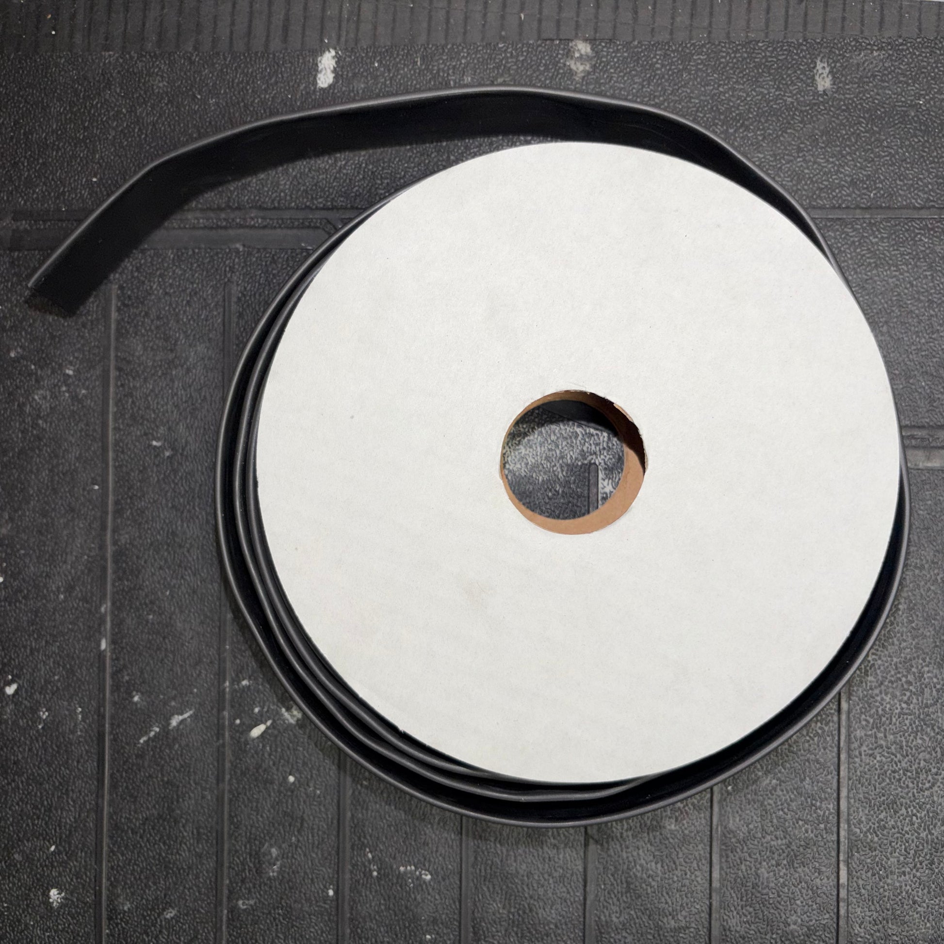 Top-down view of a mini reel spool wrapped with black heatshrink tubing.