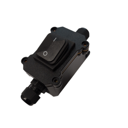 A black industrial toggle switch module with a rocker switch and threaded connector ports, shown on a plain white background.